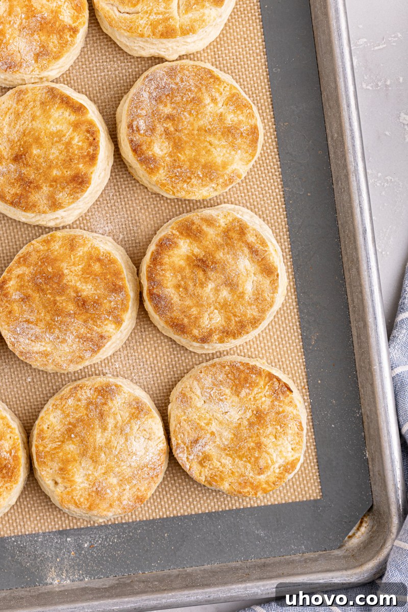 Golden brown buttermilk biscuits stacked on a pan, ready to serve.