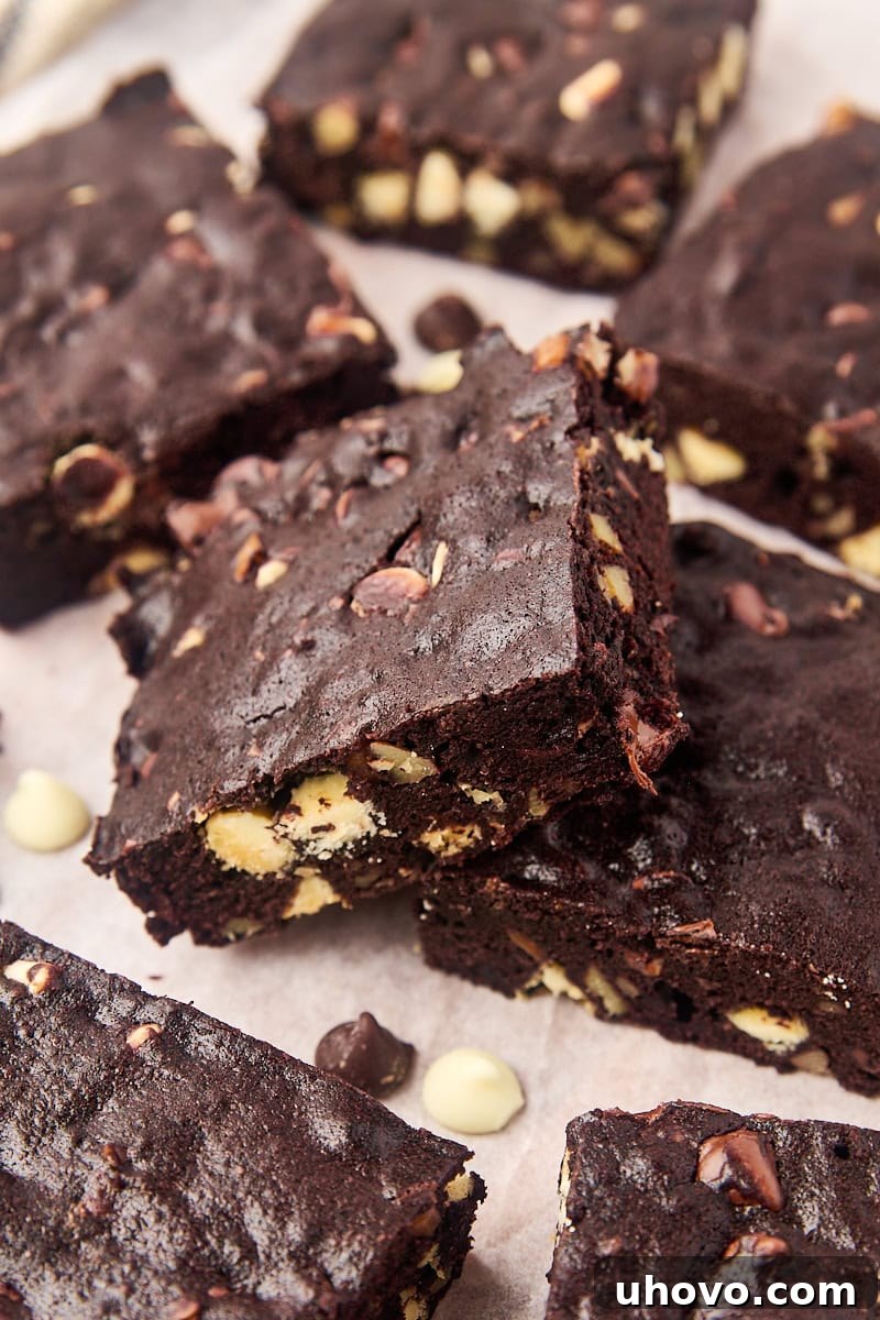 Decadent triple chocolate brownies cooling on parchment paper, ready to be cut