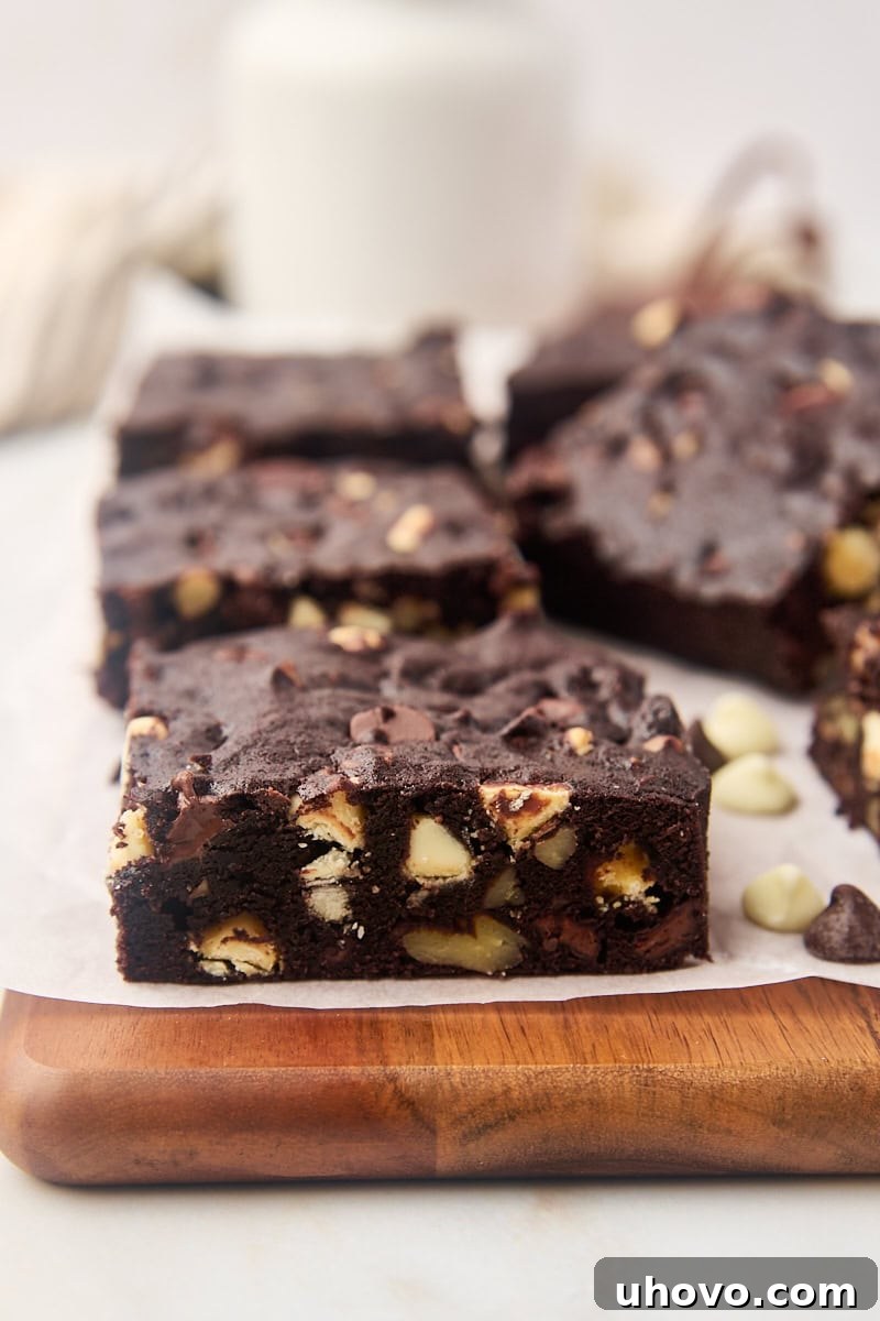 Fudgy triple chocolate brownies neatly arranged on a cutting board, ready for serving