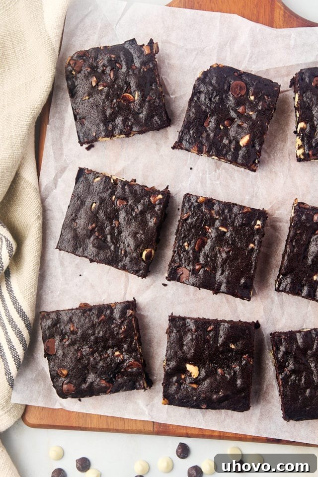 Overhead view of baked triple chocolate brownies cooling on parchment paper