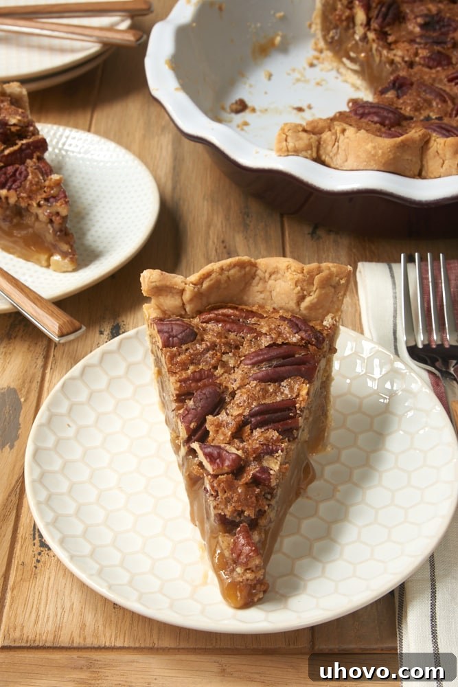 slice of Irish Cream Pecan Pie on a white and beige plate