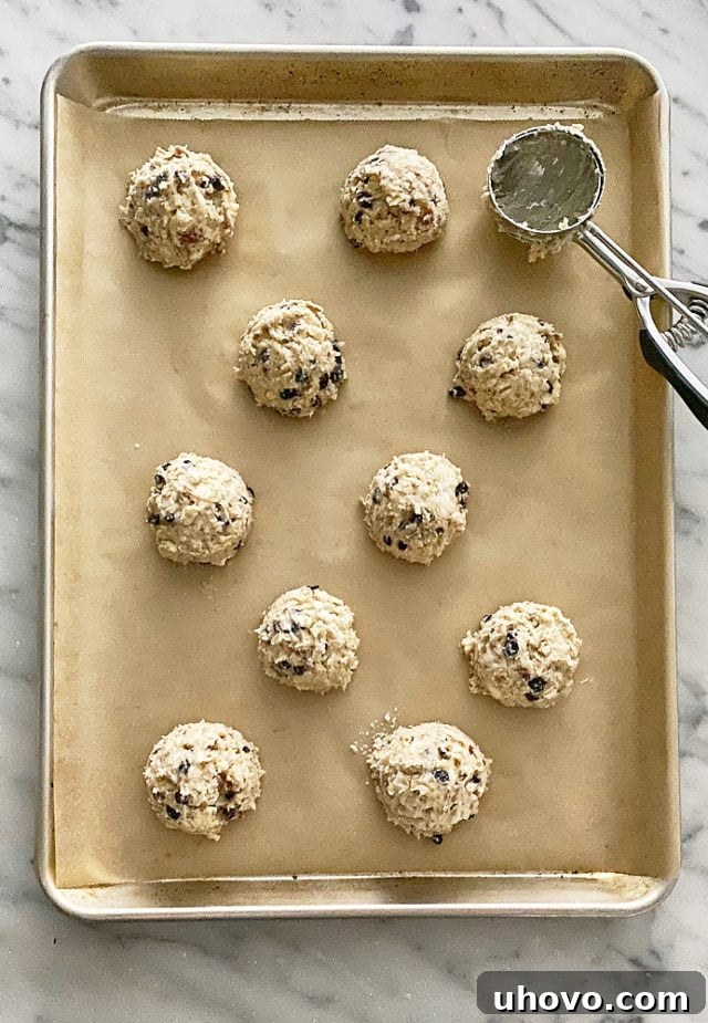 Unbaked Currant Oat Scones dough, portioned and ready for the oven on a parchment-lined baking pan.