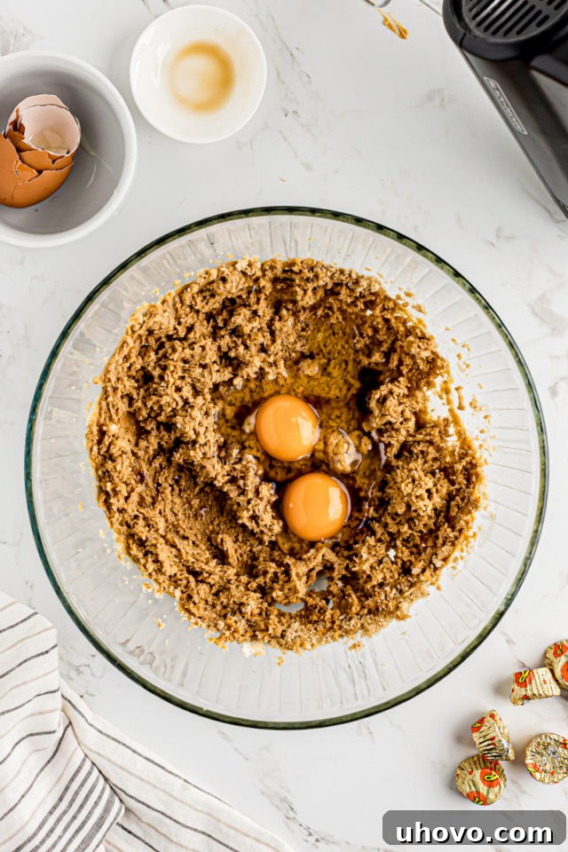 Eggs cracked into creamed butter and sugar