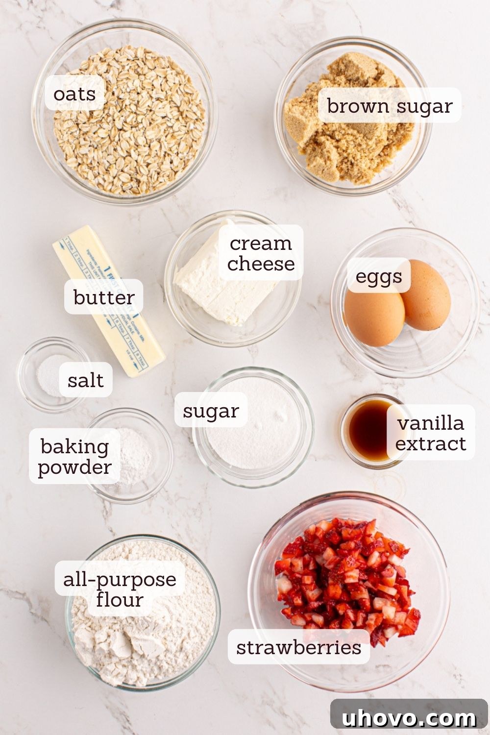 Overhead shot showcasing a pristine array of ingredients artfully arranged for making Strawberry Cream Cheese Bread, highlighting fresh strawberries and other baking essentials.