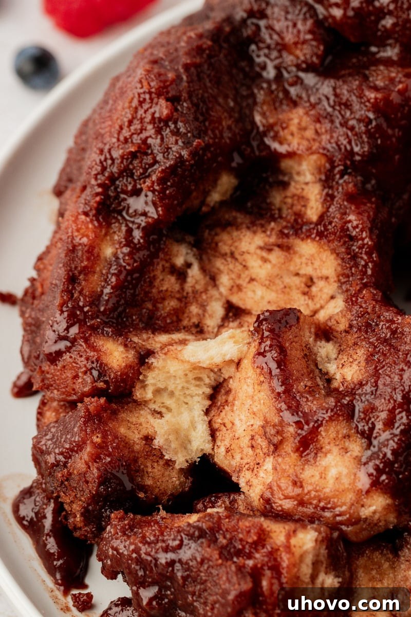 A partially served chocolate monkey bread on a platter, with a few delicious pieces already pulled away, inviting guests to help themselves.