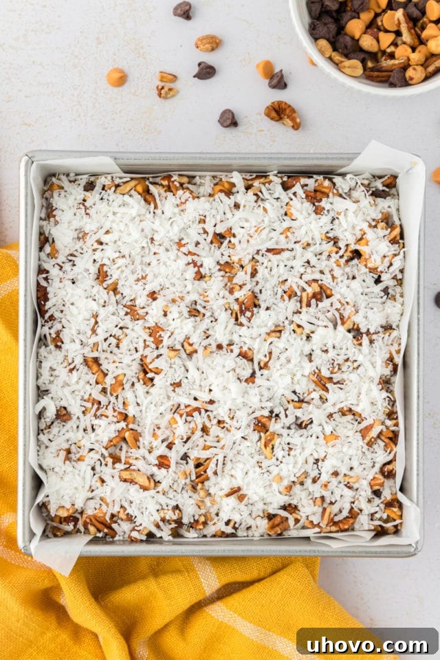 An overhead view of the fully assembled toffee squares dough, complete with a generous layer of toppings, perfectly prepped and ready for the oven.