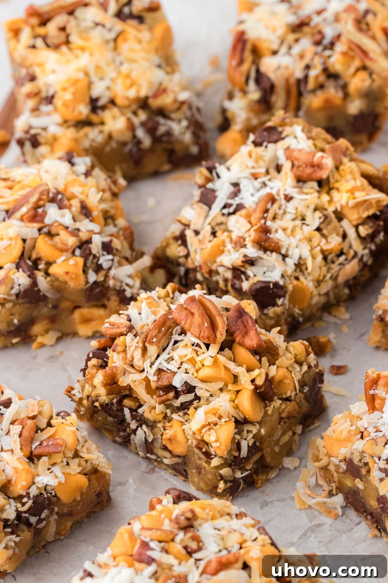 A scattered arrangement of delicious toffee squares on parchment paper, highlighting their individual perfection and generous toppings.