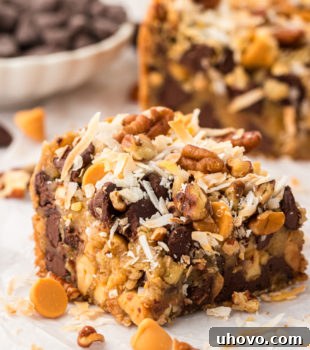 A toffee square on parchment paper with additional bars in the background