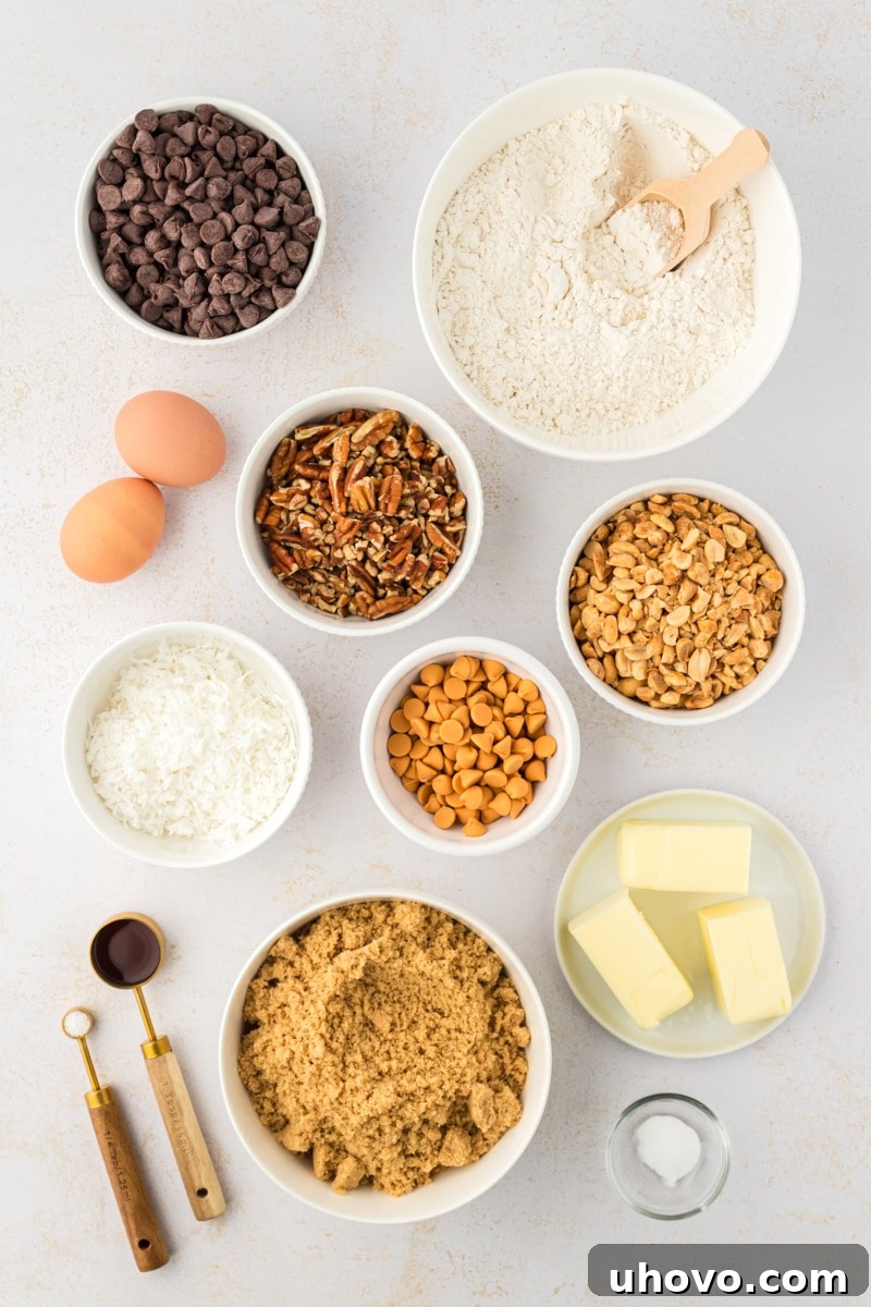 An overhead shot showcasing all the essential ingredients laid out for making Toffee Squares, including flour, sugars, butter, eggs, chips, and nuts.
