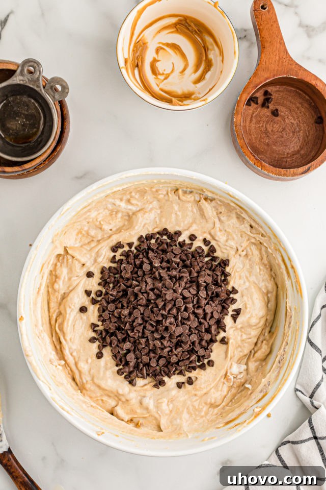 Overhead view of chocolate chips added to cream cheese mixture