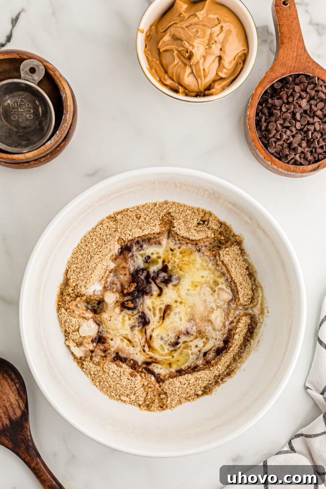 Overhead view of ingredients for graham cracker crust in mixing bowl