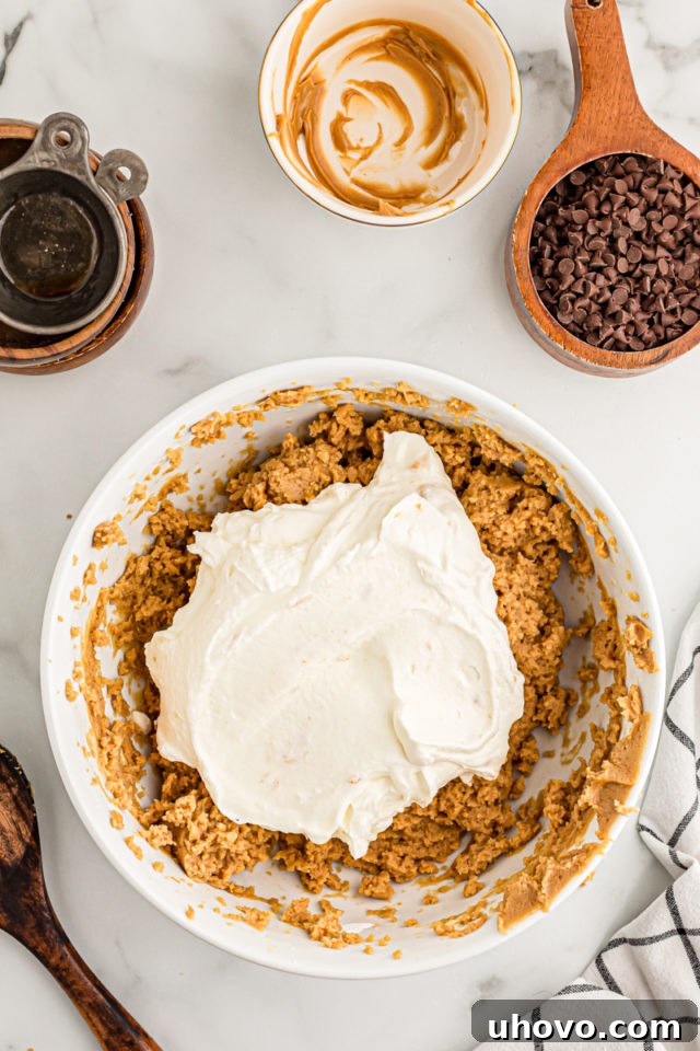 Overhead view of whipped cream added to bowl of peanut butter filling