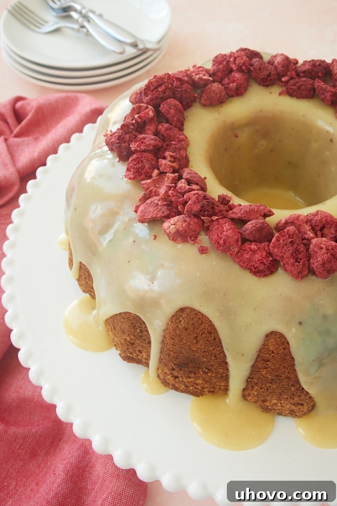 A beautiful White Chocolate Raspberry Bundt Cake, filled with berries and topped with white chocolate ganache.