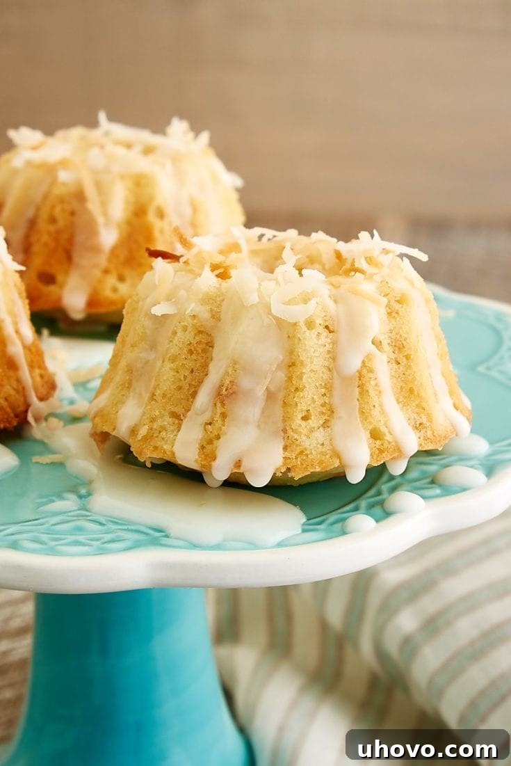 Adorable Mini Coconut Bundt Cakes, lightly toasted and glistening with glaze.