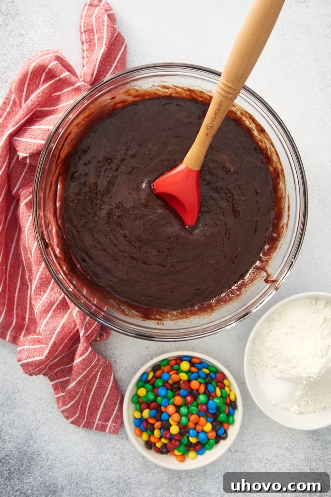 overhead view of partially mixed brownie batter in a glass bowl
