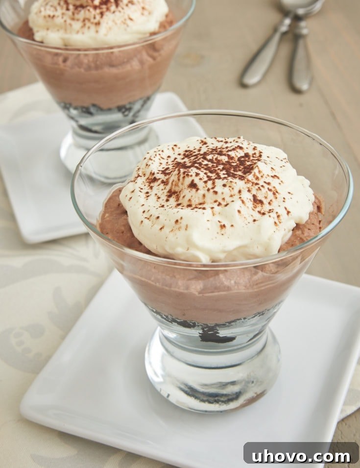 Three individual chocolate icebox pies, with fluffy whipped topping and chocolate shavings, in mini pie crusts.