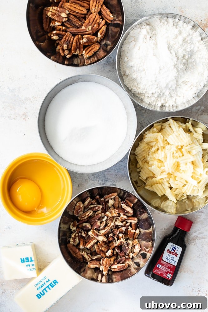 A collection of ingredients for making Potato Chip Cookies, including butter, sugar, flour, vanilla, egg yolk, crushed potato chips, and pecans, neatly arranged on a counter.