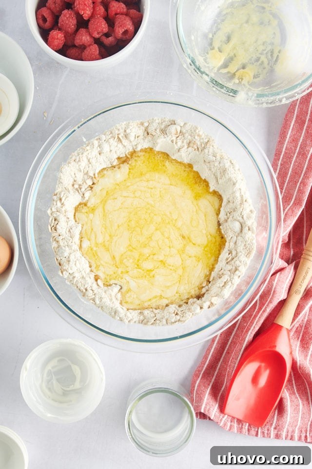 Pouring the wet ingredients into the dry ingredients for the muffin batter.