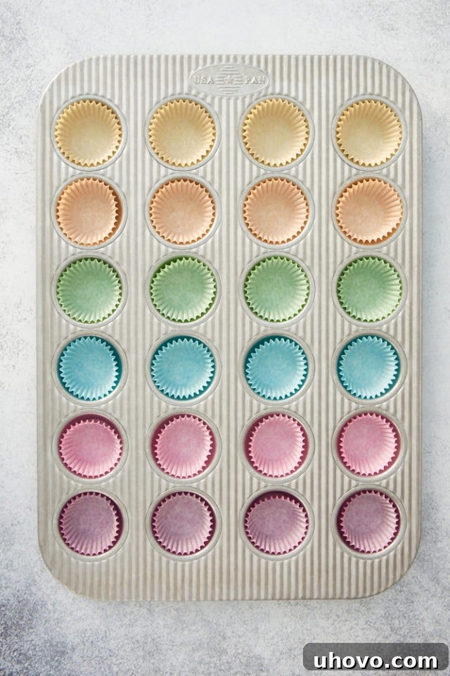 Overhead view of colorful cupcake liners in a mini muffin pan, showcasing different pan types