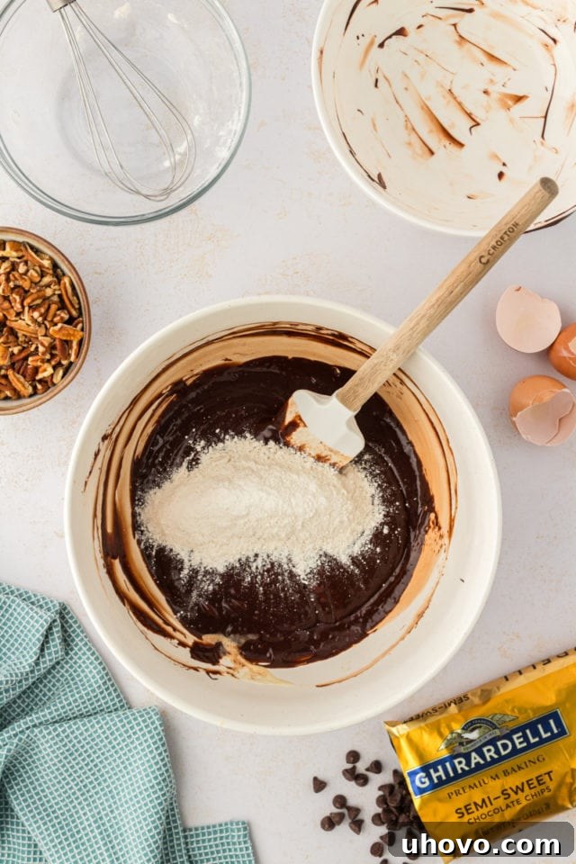 An illustrative overhead shot showing the dry ingredients being gently incorporated into the wet mixture for the double chocolate cookies.