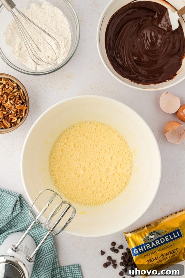 A vibrant overhead shot of the thoroughly mixed wet ingredients for the cookies in a mixing bowl, showcasing their creamy, uniform texture.