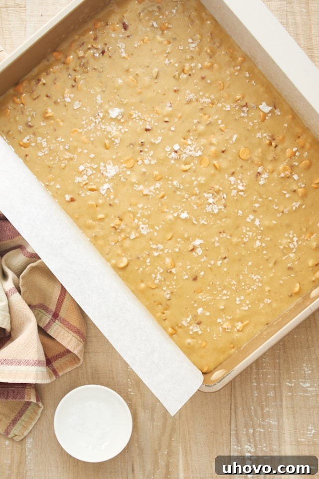 overhead view of Salted Butterscotch Blondies batter spread evenly in a parchment-lined baking pan