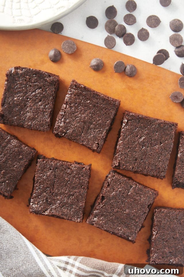 Freshly baked small batch brownies, sliced into squares on a wooden cutting board.