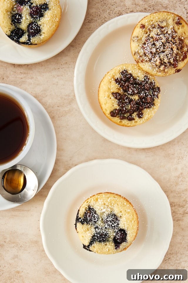 An overhead shot of freshly baked Pancake Muffins arranged on white plates, highlighting their golden tops and varied toppings, ready for a delicious breakfast or brunch.