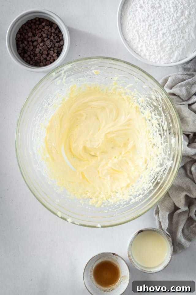 An overhead shot of creamy, whipped butter in a clear glass bowl, showcasing its light and airy texture.
