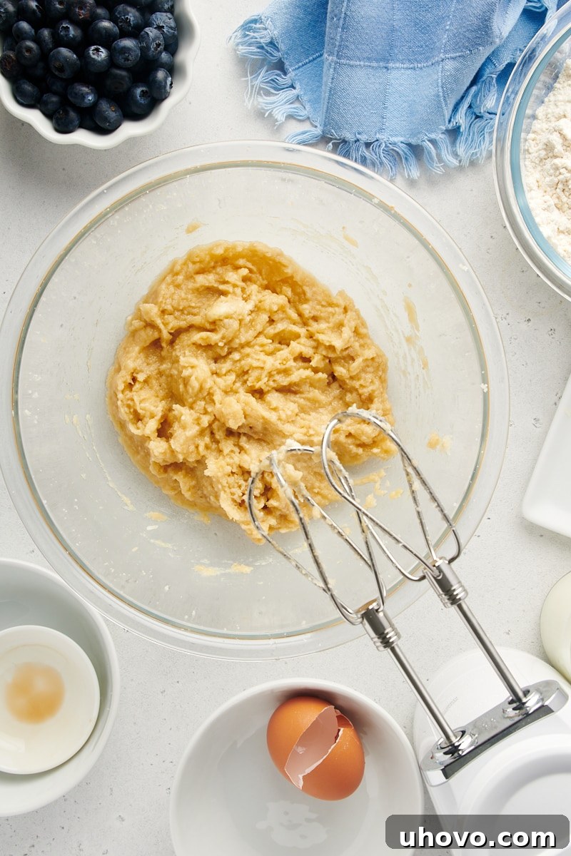 Overhead view of creamy, light yellow cake batter in a mixing bowl after the wet ingredients have been thoroughly combined.