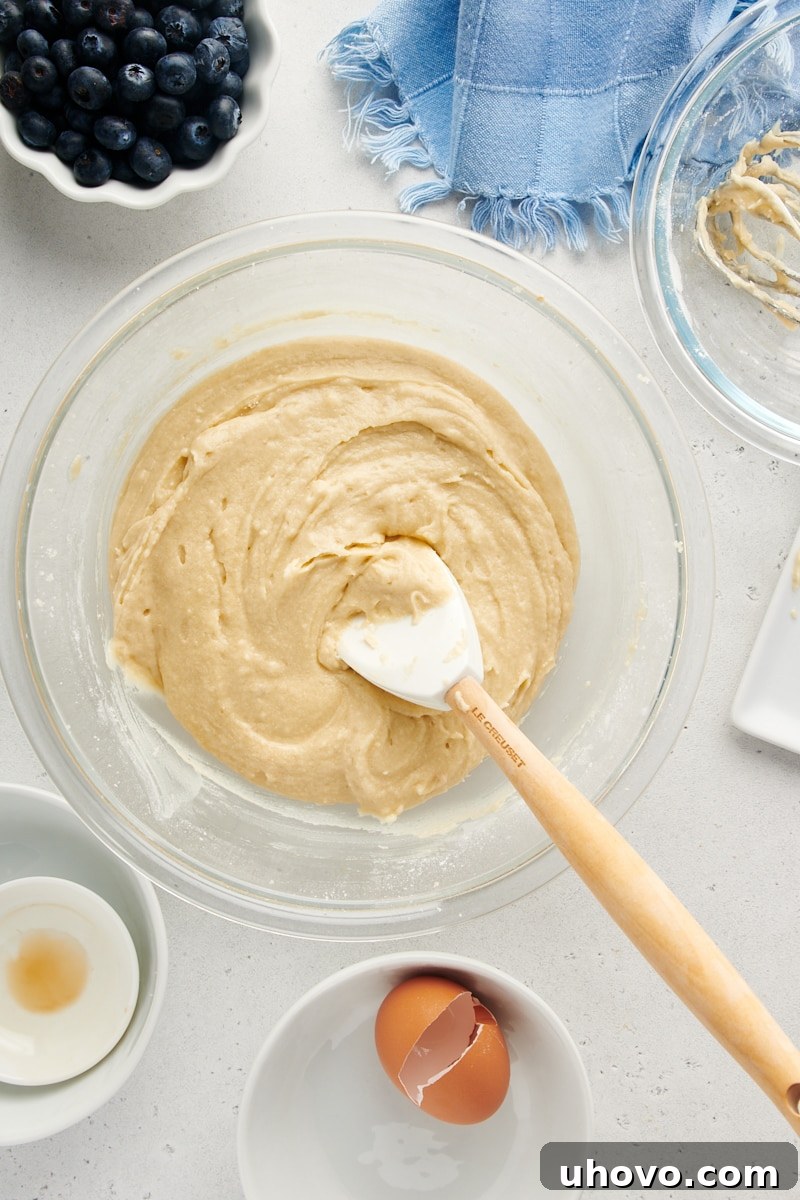 Overhead view of finished, smooth cake batter in a mixing bowl, ready for the blueberries to be added.