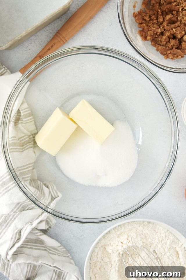 Close-up of butter and granulated sugar beautifully creamed together in a glass mixing bowl, showcasing their light, fluffy texture, ready for the next step.