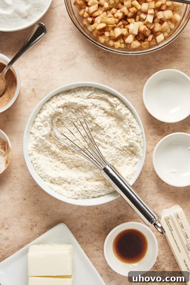 Dry ingredients for pear cake (flour, baking powder, salt) mixed in a clear glass mixing bowl, showing a uniform blend.