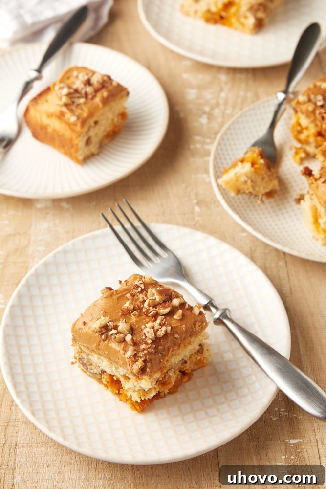 Slices of Brown Sugar Snack Cake with Dulce de Leche Frosting elegantly arranged on white and beige plates.