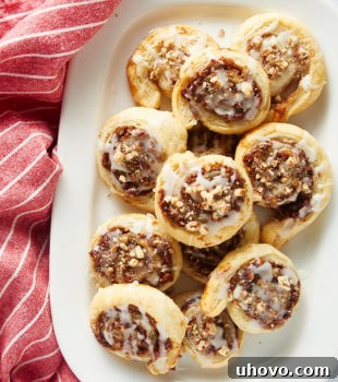 overhead view of Apple Butter Pinwheels on a large white plate next to a red and white striped kitchen towel