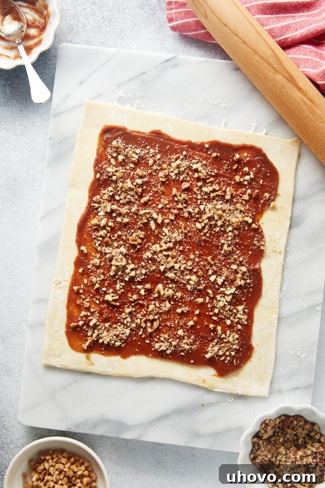 overhead view of apple butter, chopped pecans, and toffee bits spread on puff pastry