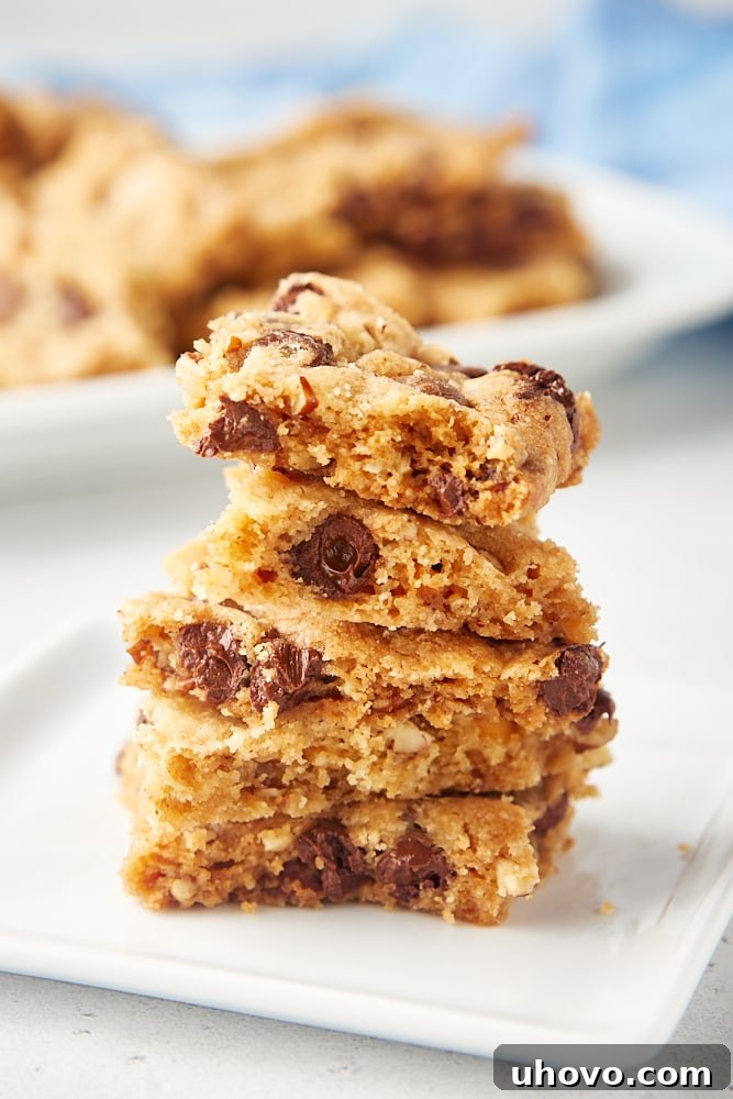 A beautifully arranged stack of Triple Chocolate Chip Cookie Brittle pieces on a minimalist square white plate, ready for serving.