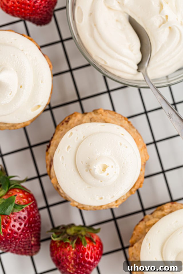 Overhead view of frosted strawberry cupcakes arranged on a cooling rack