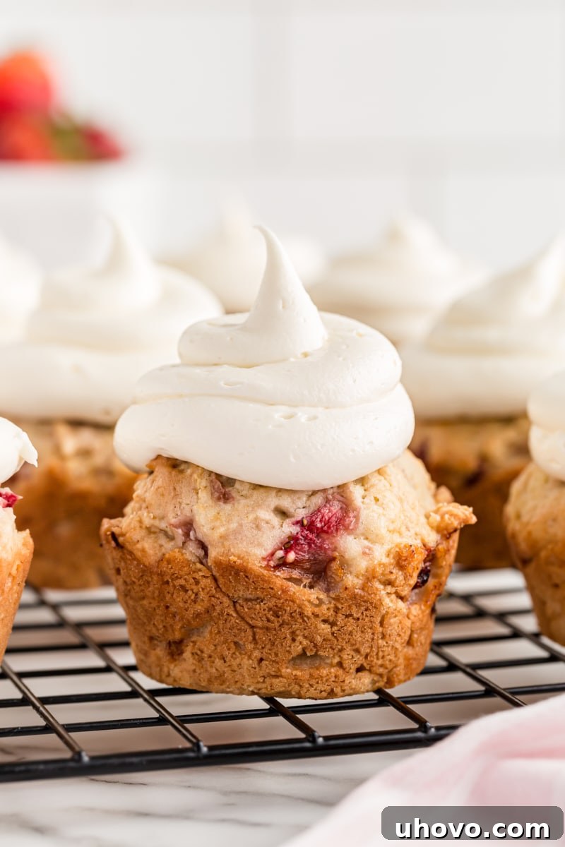 Freshly baked strawberry cupcakes cooling on a wire rack, ready to be frosted