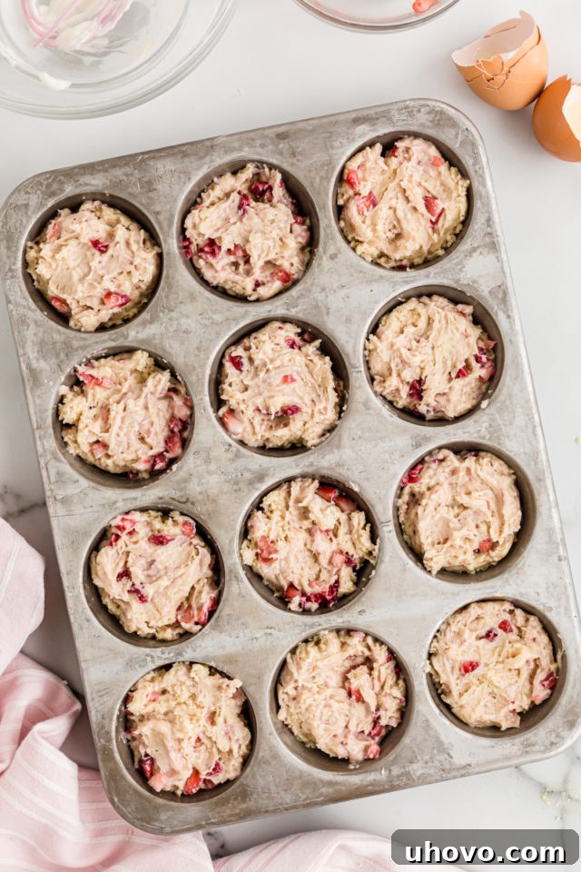 Cupcake batter neatly scooped into a muffin tin, ready for baking