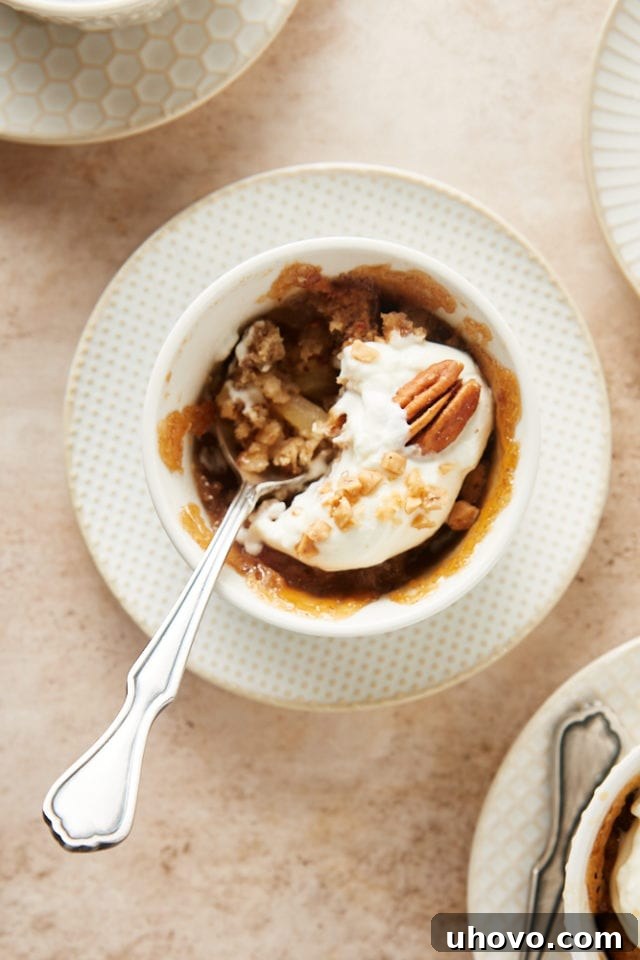 overhead view of a Ginger Pear Pudding Cake with a bite missing and a spoon resting in the ramekin