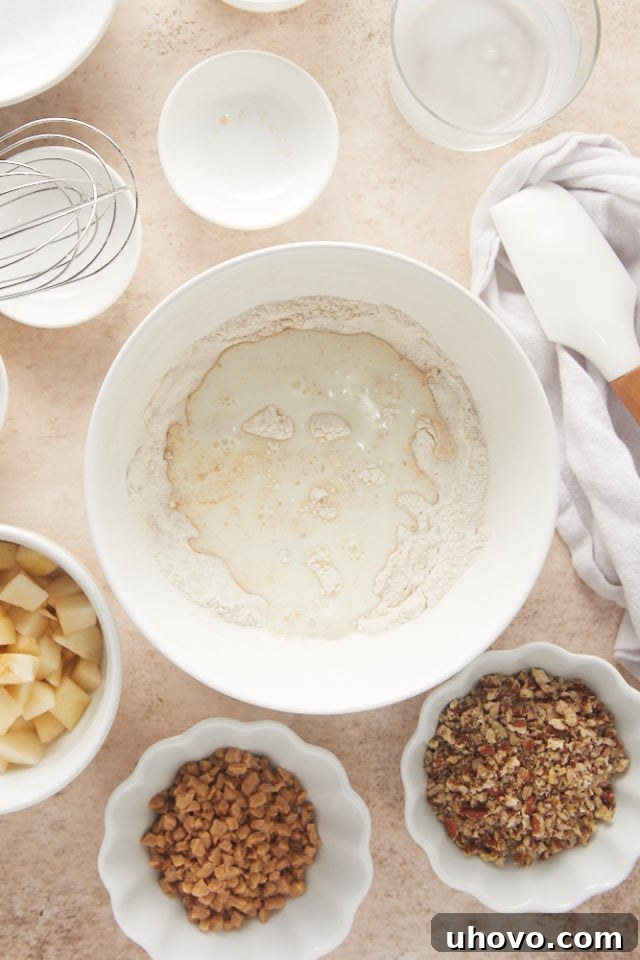 overhead view of milk added to dry ingredients in a white mixing bowl