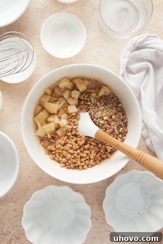 overhead view of pears, pecans, and toffee bits added to cake batter