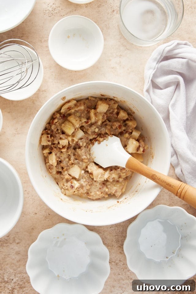 overhead view of mixed pear pudding cake batter in a white mixing bowl