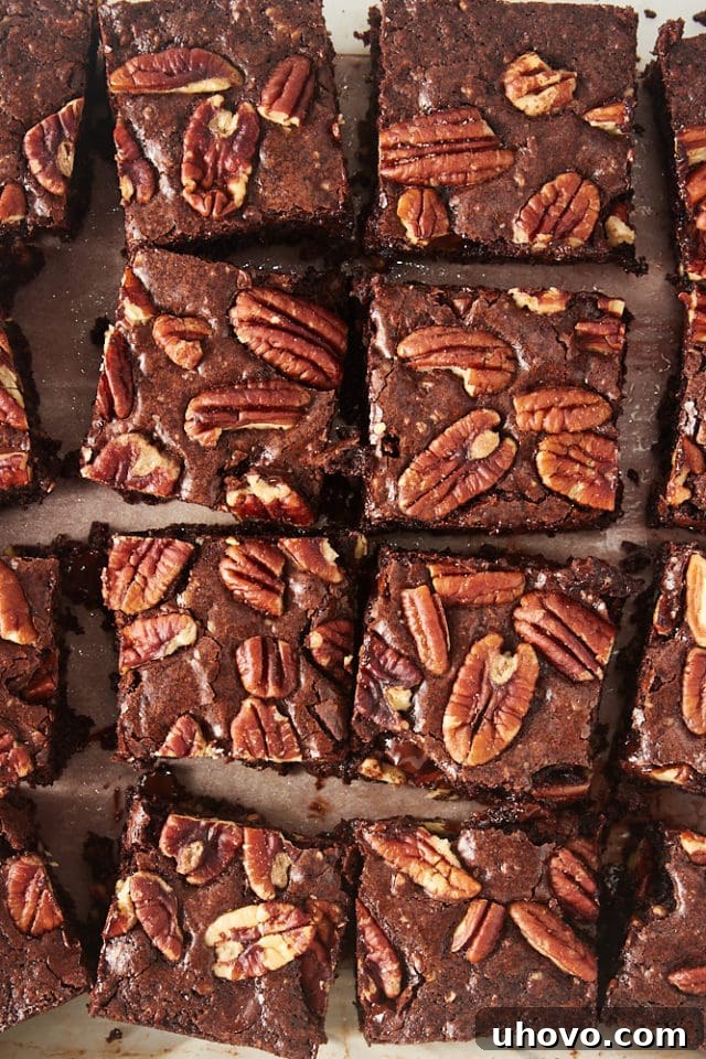 A close-up, overhead shot of Pecan Lovers' Brownies cut into perfect squares, highlighting their dense, fudgy texture and the delightful pecan bits within.