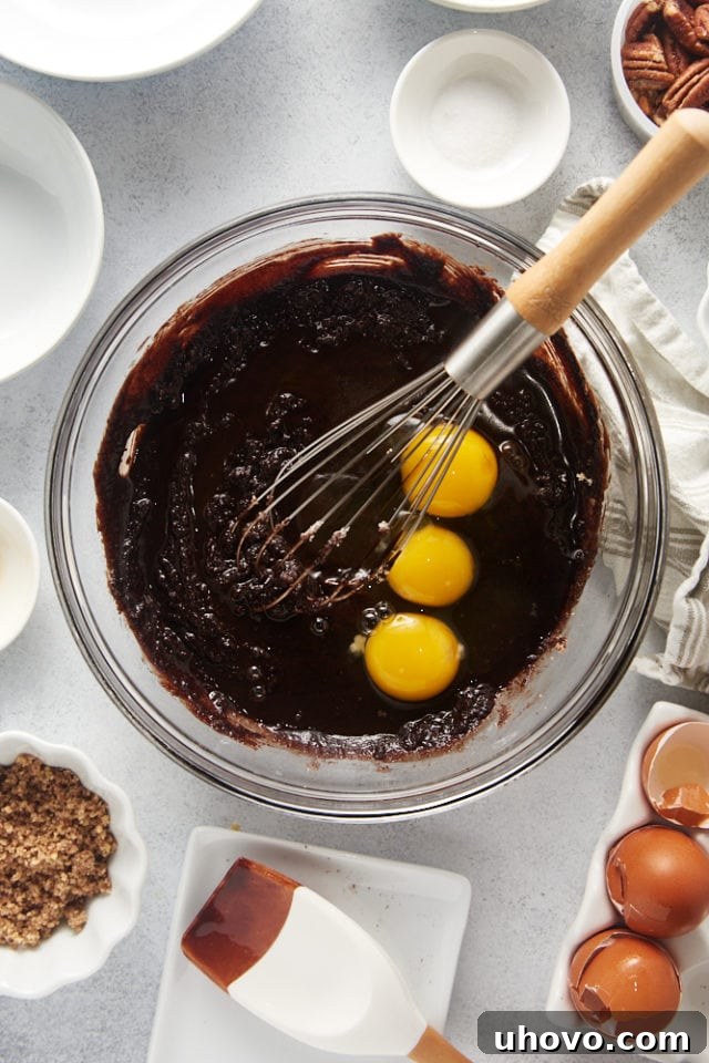 Cracked eggs just added to the brownie batter, waiting to be mixed into the rich chocolate base.