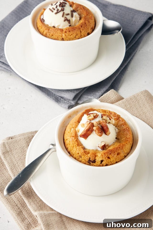 Two Deep Dish Chocolate Chip Cookies for Two, served elegantly in white ramekins on white plates, accented by natural beige and gray napkins, inviting a delicious dessert moment.