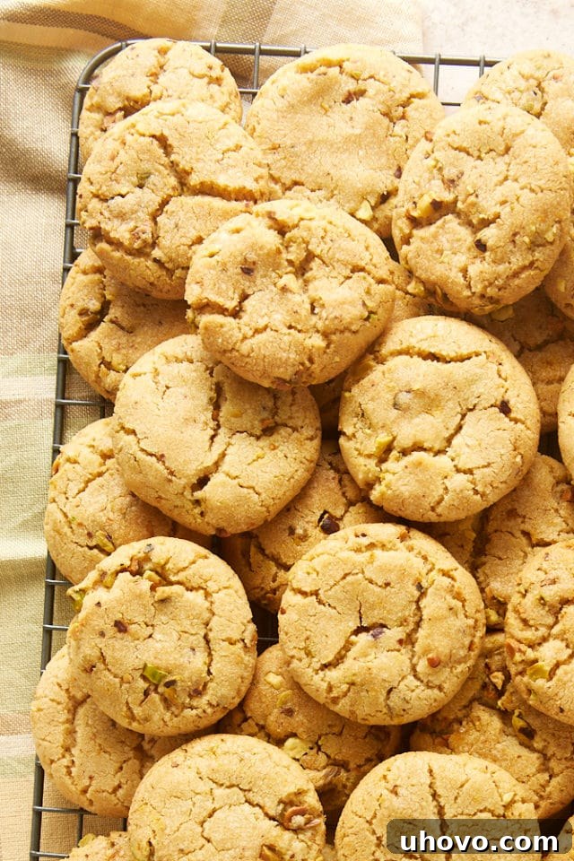 A generous pile of perfectly baked Brown Butter Pistachio Cookies rests on a wire rack, ready for sharing or enjoying.