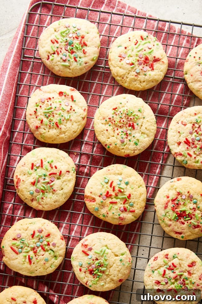 Overhead view of soft Christmas sprinkle sugar cookies neatly arranged and cooling on a wire rack.