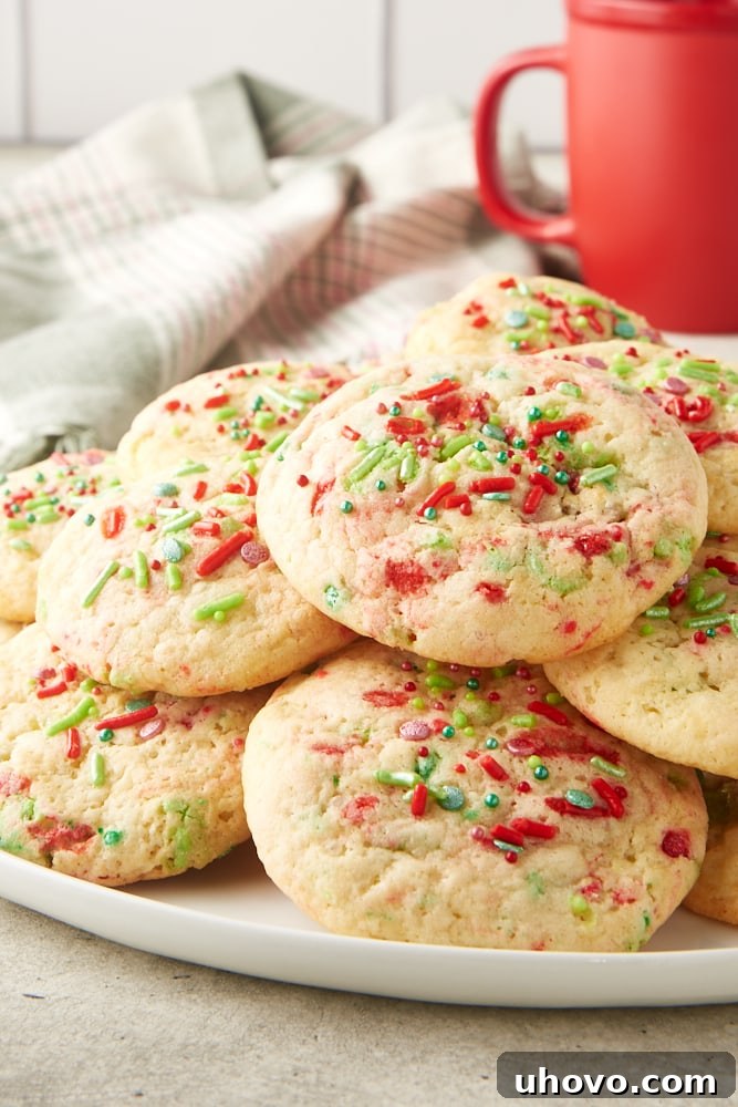 A bountiful pile of soft Christmas sugar cookies presented on an elegant white serving plate, ready for sharing.